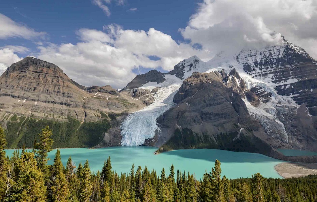 A glacier on Mount Robson in the Canadian Rockies flowing into a turquoise lake.